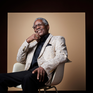 Don Bryant sitting on a chair in front of a beige backdrop