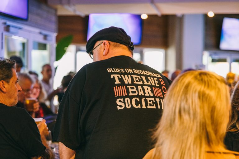 man wearing a black tshirt that say twelve bar society on the back